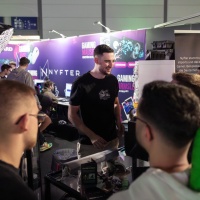 Besucher werden an einem Stand für Gaming Hardware beraten.